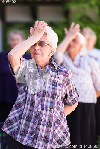 Image of senior woman exercising with friends