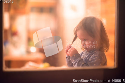 Image of little cute girl playing near the window