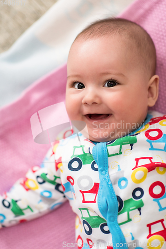 Image of top view of newborn baby boy lying on colorful blankets