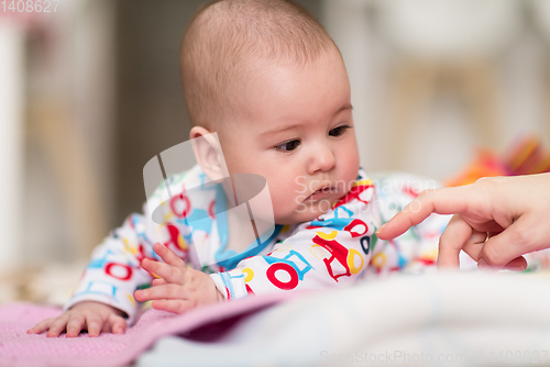 Image of newborn baby boy playing on the floor