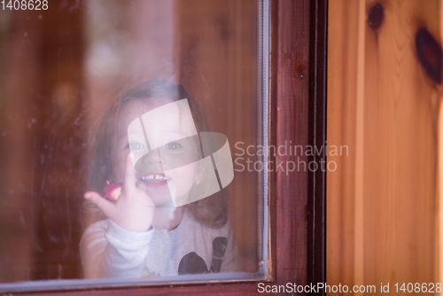 Image of little cute girl playing near the window