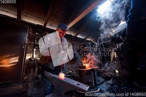Image of blacksmith manually forging the molten metal