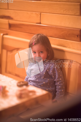 Image of little cute girl playing near the window