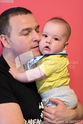 Image of portrait of happy young father holding baby isolated on red