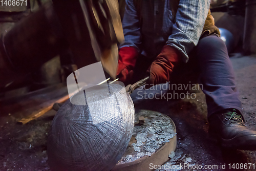 Image of blacksmith workers using mechanical hammer at workshop