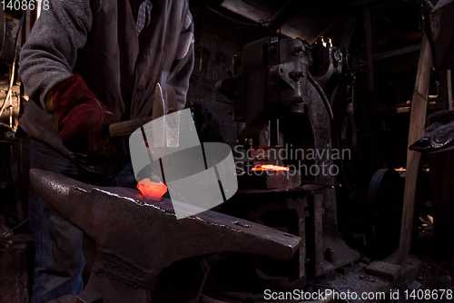 Image of blacksmith manually forging the molten metal