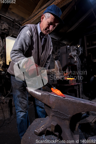 Image of blacksmith manually forging the molten metal