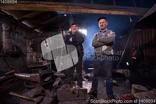 Image of portrait of two generations confident blacksmith