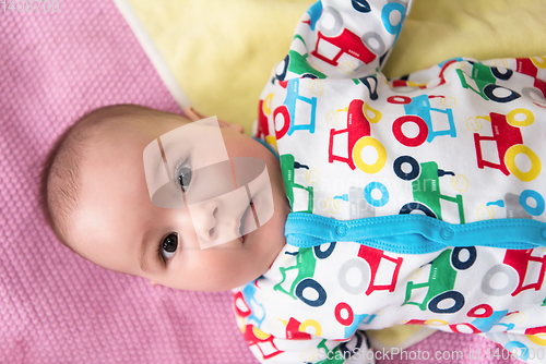 Image of top view of newborn baby boy lying on colorful blankets