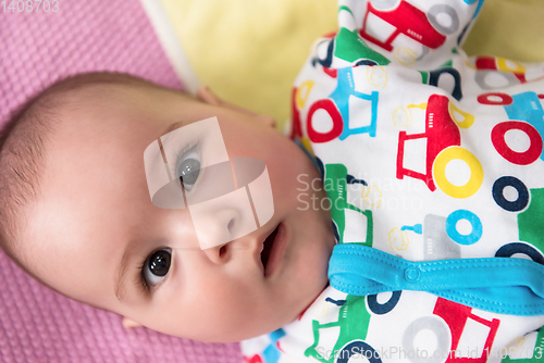 Image of top view of newborn baby boy lying on colorful blankets