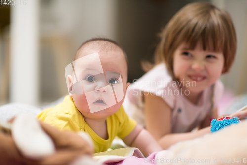 Image of little sister and her baby brother playing at home