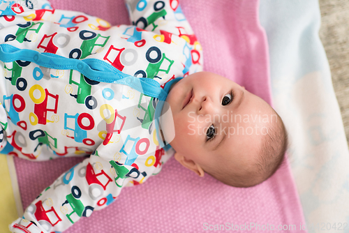 Image of top view of newborn baby boy lying on colorful blankets