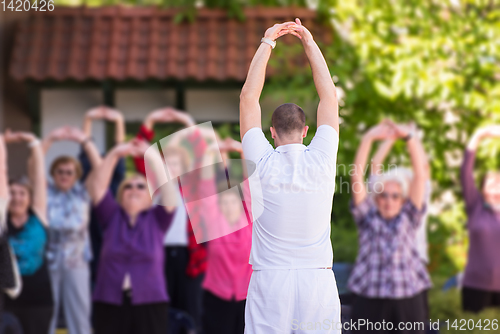 Image of trainer training motivated active healthy senior people