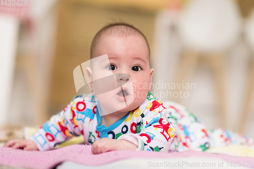 Image of newborn baby boy playing on the floor