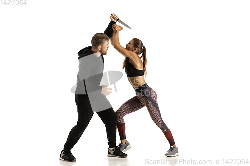 Image of Man and woman fighting in studio, women\'s self-defense concept