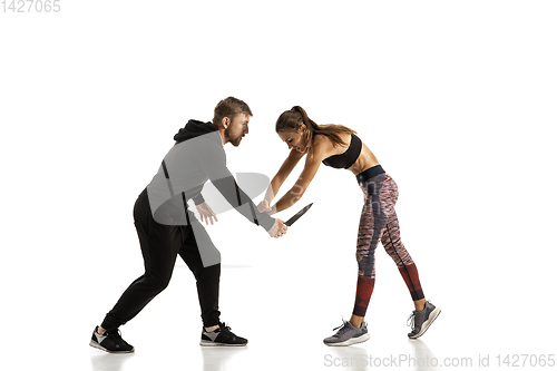 Image of Man and woman fighting in studio, women\'s self-defense concept