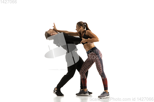 Image of Man and woman fighting in studio, women\'s self-defense concept