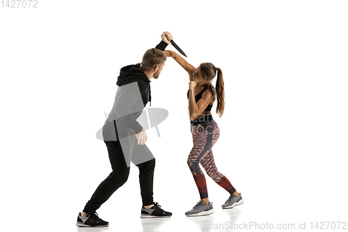 Image of Man and woman fighting in studio, women\'s self-defense concept