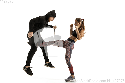 Image of Man and woman fighting in studio, women\'s self-defense concept