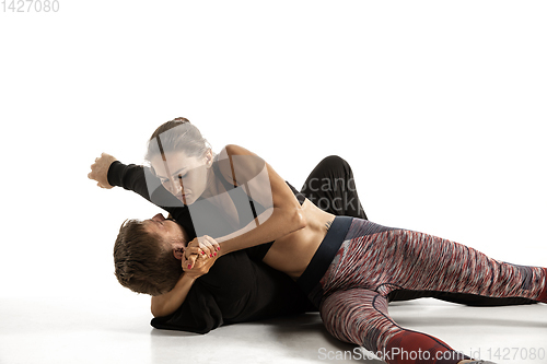 Image of Man and woman fighting in studio, women\'s self-defense concept