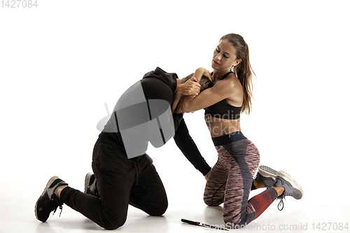 Image of Man and woman fighting in studio, women\'s self-defense concept