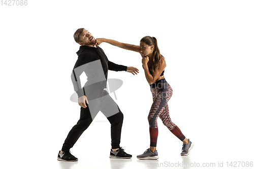 Image of Man and woman fighting in studio, women\'s self-defense concept