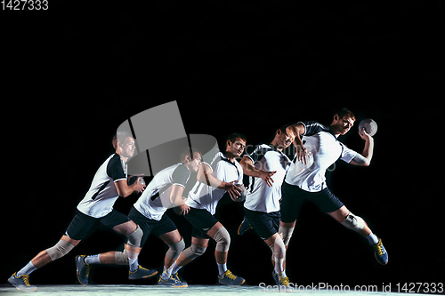 Image of Young handball player against dark studio background in strobe light