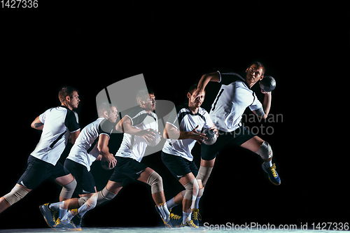 Image of Young handball player against dark studio background in strobe light