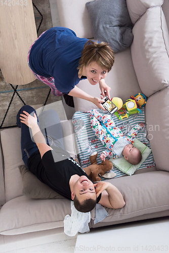 Image of top view of happy mother and father taking picture of baby