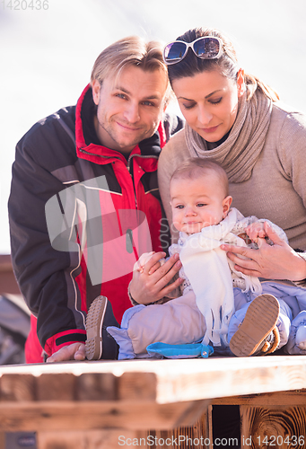 Image of young happy family with little child enjoying winter day