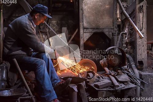 Image of the blacksmith polishing metal products