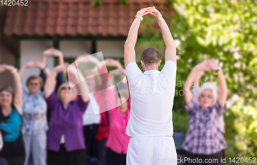 Image of trainer training motivated active healthy senior people