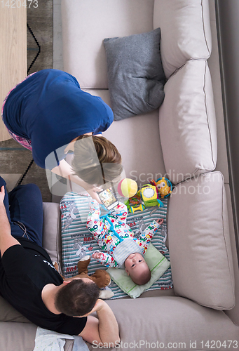 Image of top view of happy mother and father taking picture of baby