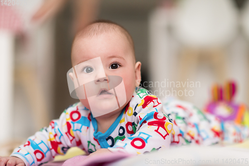 Image of newborn baby boy playing on the floor