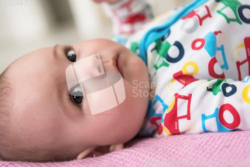 Image of newborn baby boy lying on colorful blankets