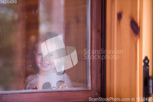 Image of little cute girl playing near the window