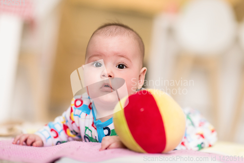 Image of newborn baby boy playing on the floor