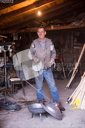 Image of A blacksmith worker showing handmade products ready for sale