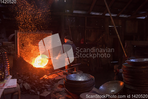 Image of blacksmith workers using mechanical hammer at workshop