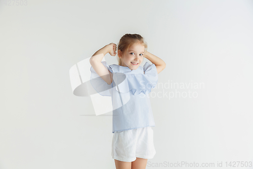 Image of Little smiling girl posing in casual clothes on white studio background