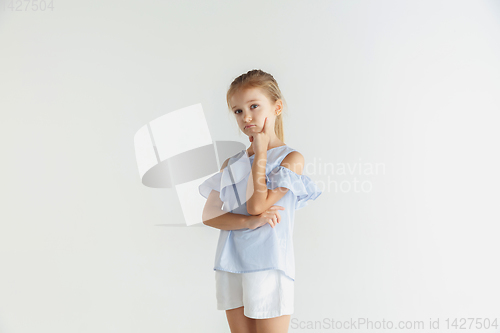 Image of Little smiling girl posing in casual clothes on white studio background