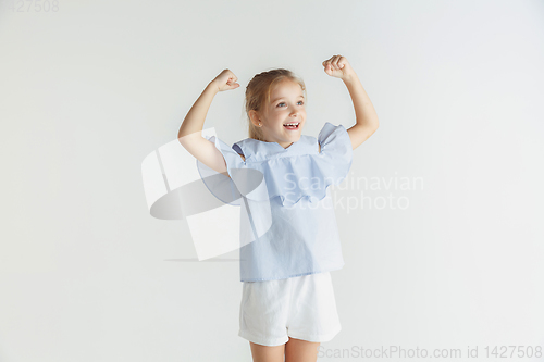 Image of Little smiling girl posing in casual clothes on white studio background