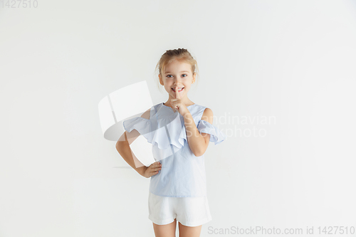 Image of Little smiling girl posing in casual clothes on white studio background