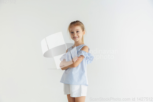 Image of Little smiling girl posing in casual clothes on white studio background