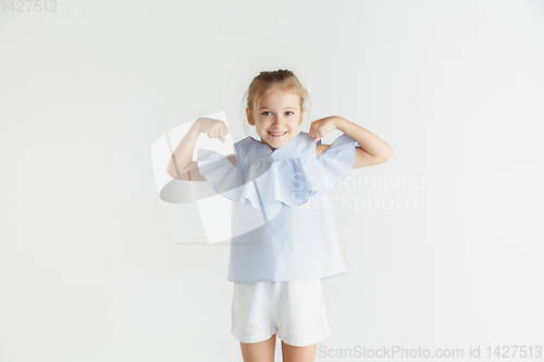 Image of Little smiling girl posing in casual clothes on white studio background