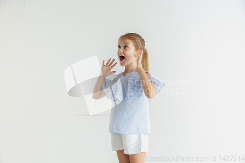 Image of Little smiling girl posing in casual clothes on white studio background