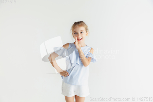 Image of Little smiling girl posing in casual clothes on white studio background