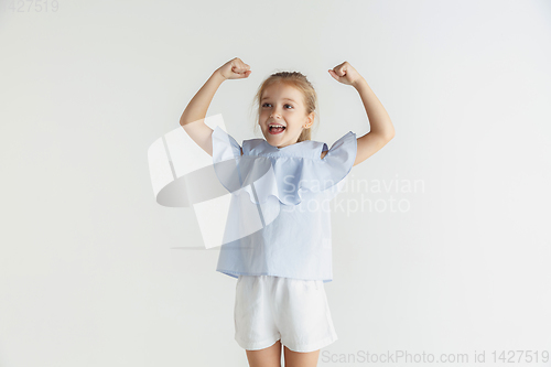 Image of Little smiling girl posing in casual clothes on white studio background