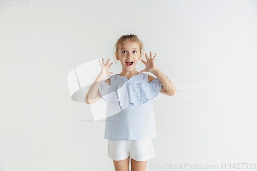 Image of Little smiling girl posing in casual clothes on white studio background