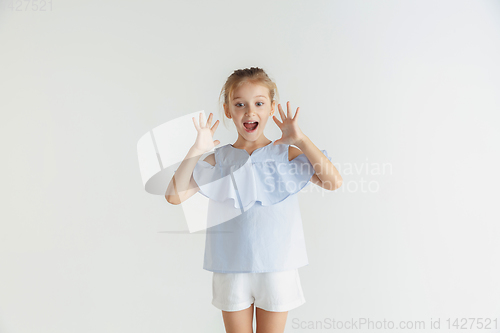 Image of Little smiling girl posing in casual clothes on white studio background